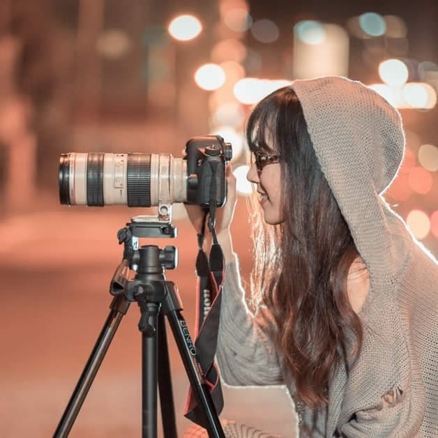 jeune femme prend une photo de nuit dans la rue